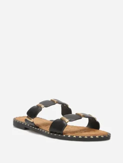 New La Modeuse Mules à brides festonnées et détails dorés Noir