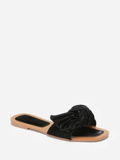 La Modeuse Mules à large bride matelassée et nouée Noir