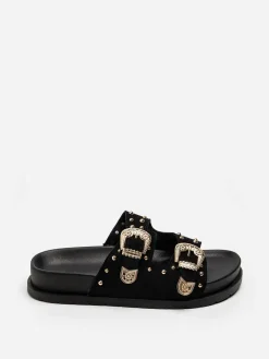 Outlet La Modeuse Mules en suédine à boucles et clous dorés Noir
