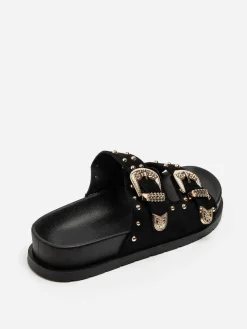 Outlet La Modeuse Mules en suédine à boucles et clous dorés Noir
