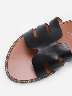 La Modeuse Mules plates à bride ajourée et clous Noir