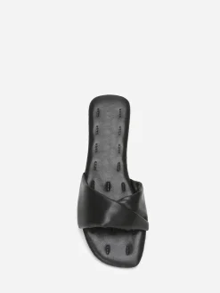 La Modeuse Mules plates à bride torsadée en simili Noir